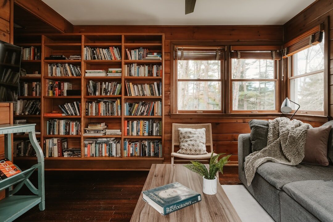 Cozy home library with wooden shelves full of books and a reading lamp